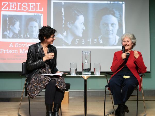 Margaret Gould Stewart and Jean Richards sit on stage and hold microphones.