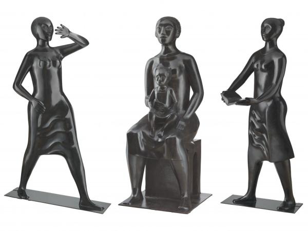 Three bronze statues of women - one holding her hand to protect her face, one with a child on her lap, and one holding a book