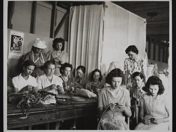 Group of women with light skin tones weaving baskets