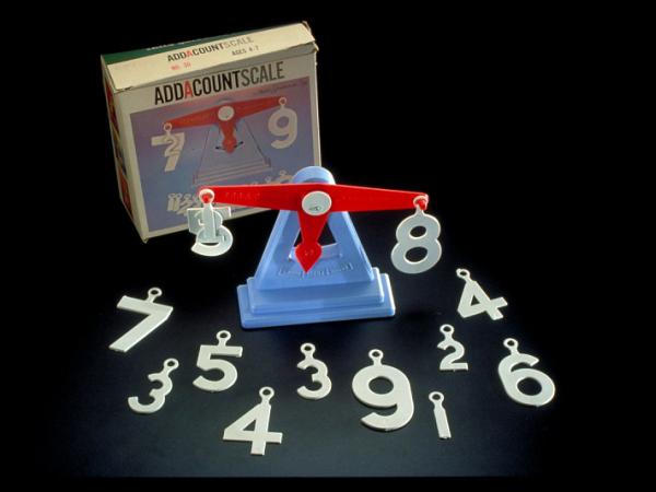 Toy scale with numbers that can be hung on each end, and a box for the toy