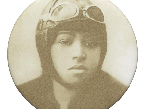 A circular button featuring a sepia portrait of Bessie Coleman wearing an aviator hat and goggles.