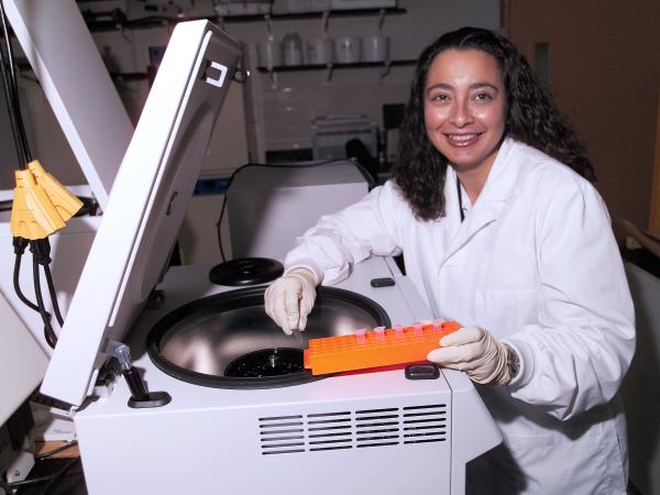 Scientist Oris Sanjur using a centrifuge.