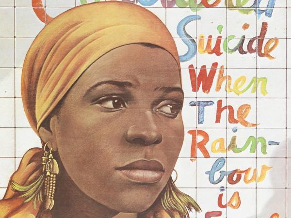 An African American woman looks out of frame. Next to her the title of the play is written in cursive rainbow letters: for colored girls who have considered suicide / when the rainbow is enuf