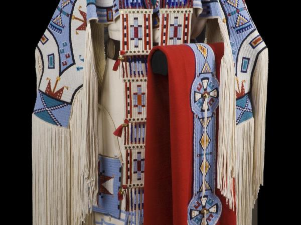 A traditional Dakhóta/Nakoda dress in white, blue, red, and black