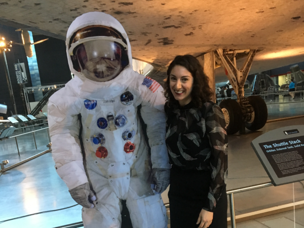 Dr. Emily Margolis stands next to a spacesuit