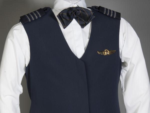 Blue wool blouse; sleeveless; 6 hidden buttons down front; blue and gold 4 stripe captain insignia shoulderboards