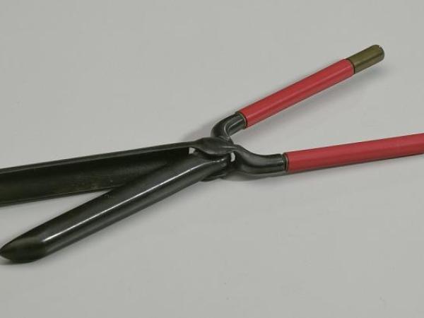 A curling iron with a metal barrel with a clamp that closes to halfway cover the barrel and two handles that are covered with an insolating material