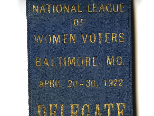 Blue banner that says &quot;National League of Women Voters.&quot; Atop the ribbon is a name tag that reads &quot;Miss Alice S. Blackwell.&quot;  