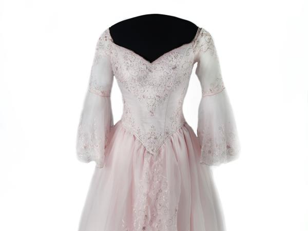 Pink dress with bell sleeves and a full skirt. The dress includes beading and sequins in floral designs.