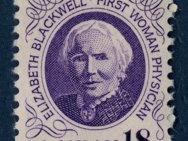 Purple and white stamp featuring a portrait of Elizabeth Blackwell. It includes text &quot;Elizabeth Blackwell, First Woman Physician.&quot;