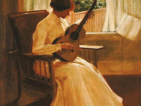 Woman in a long white dress playing guitar