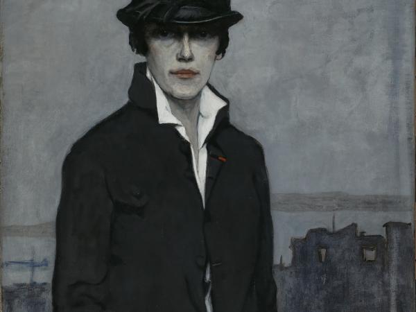 Romaine Brooks portrays herself in the dark colors of a man&#039;s outfit, her eyes veiled under the shadow of her hat brim. 