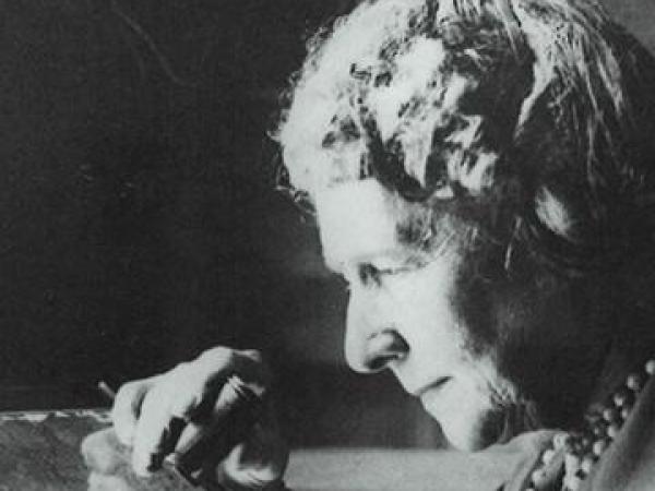 Annie Jump Cannon inspects a glass plate while conducting an astronomy experiment