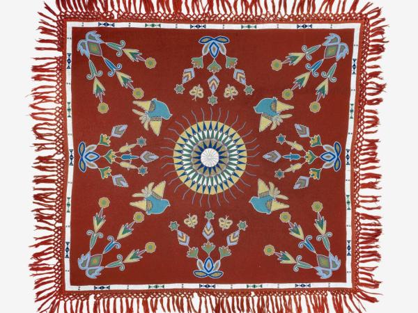 A red tablecloth with a circle in the middle and different designs around it