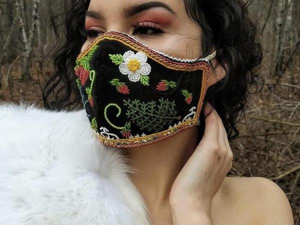 Photograph of a woman wearing a face mask with beaded flowers