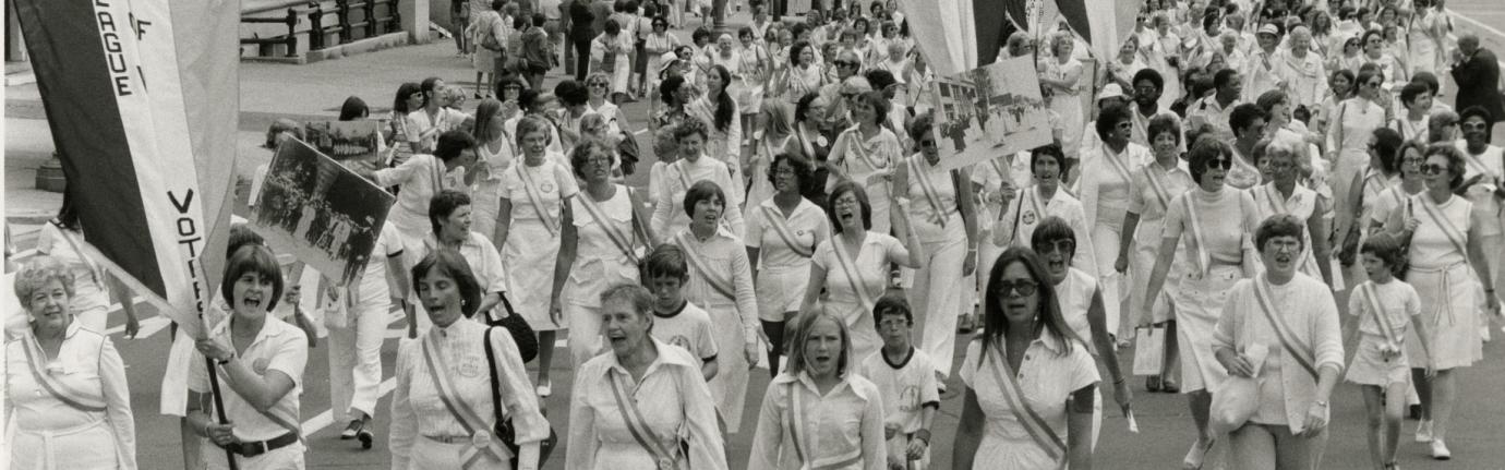 group of women dressed in white marching in parade