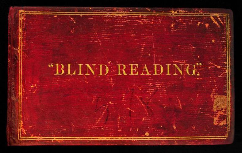 Red leather bound book with a gold border and text that says Blind Reading Album