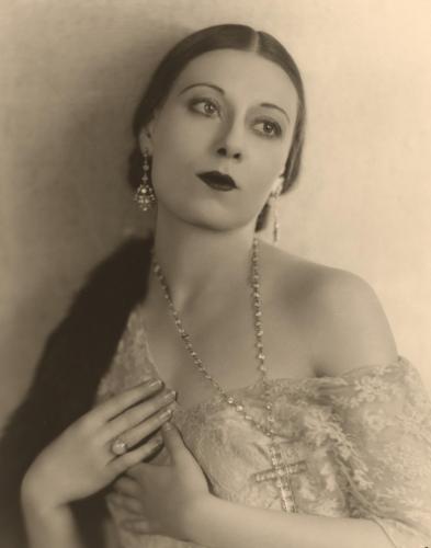 Photograph of Dolores del Río wearing an opulent outfit and makeup while looking off into the distance