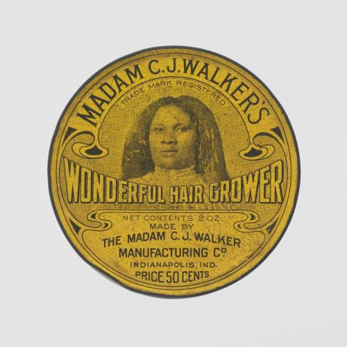 The canister is metal with yellow lacquer coloring its external surface, with text and images in black ink. WONDERFUL HAIR GROWER is written in horizontal text across the center of the lid beneath an ink illustration of a black woman pictured.