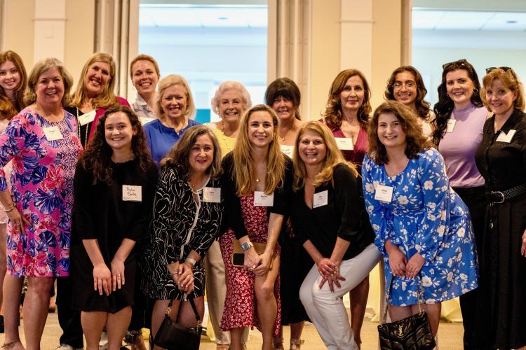 Group of sixteen women facing the camera smiling 