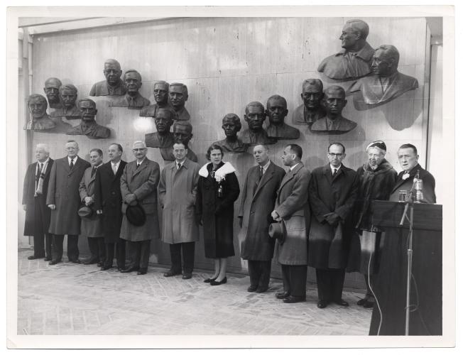 Group of people stand in front of a wall