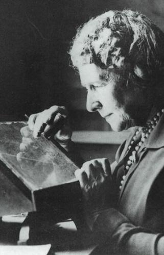 Annie Jump Cannon inspects a glass plate while conducting an astronomy experiment