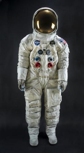 White space suit with NASA patches and a U.S. flag on the left shoulder