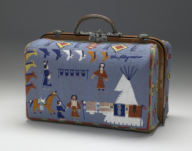 A blue suitcase made of beads with designs of people, a teepee, and animals.