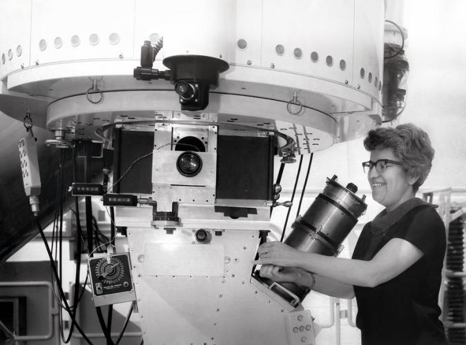 Black and white photograph of Vera Rubin standing at the 36-inch telescope at Kitt Peak National Observatory.