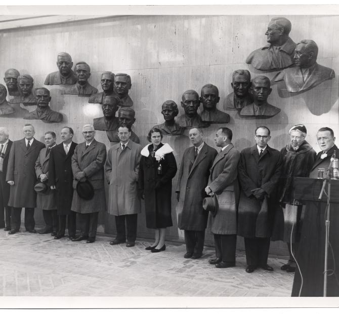 Group of people stand in front of a wall