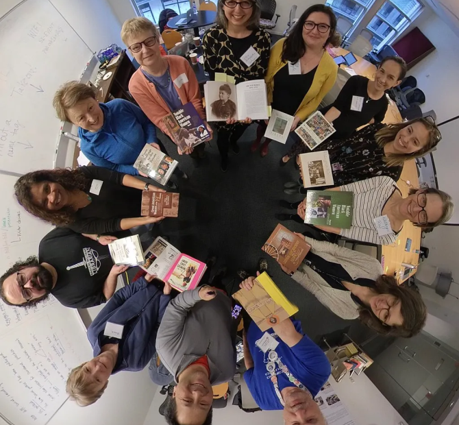 People standing in a circle with books in their hands 